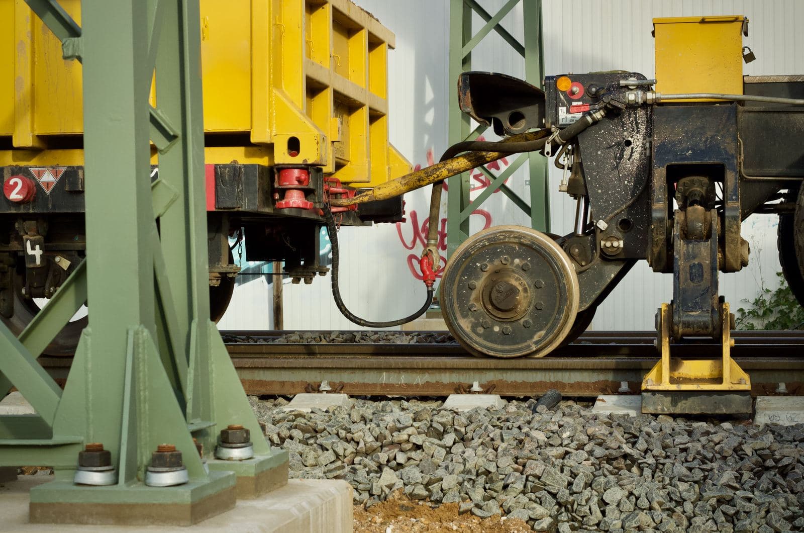 Close-up of a freight car's wheel, coupler, and air hose at trackside